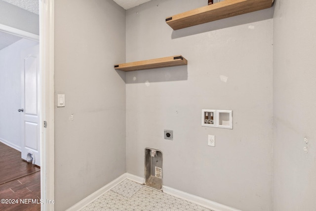 laundry area featuring hookup for an electric dryer, hookup for a washing machine, and a textured ceiling