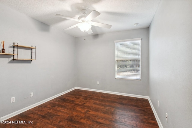 spare room with a textured ceiling, ceiling fan, and dark wood-type flooring