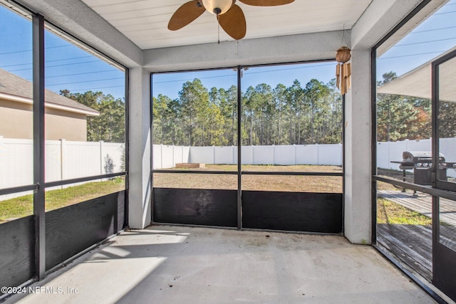 unfurnished sunroom featuring ceiling fan