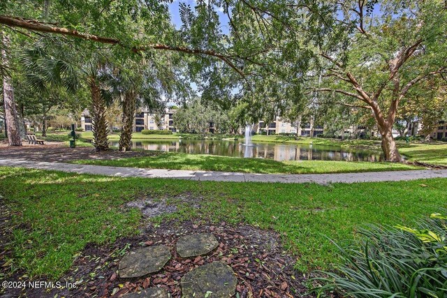 view of community featuring a lawn and a water view