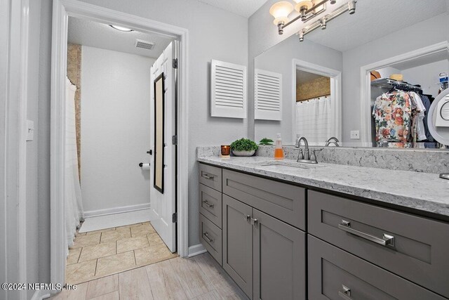 bathroom featuring vanity, a textured ceiling, and hardwood / wood-style flooring