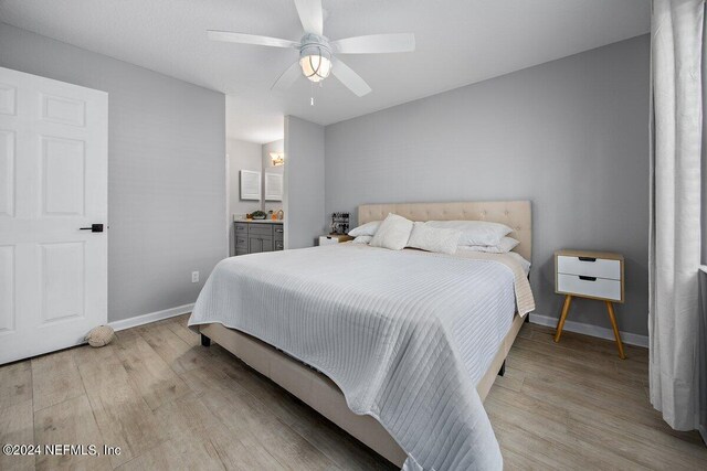 bedroom featuring light wood-type flooring, connected bathroom, and ceiling fan