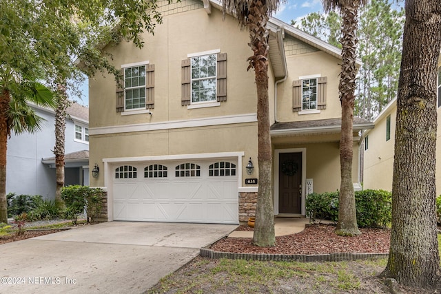 635 Briar View Dr, Orange Park, FL 32065 - view of front of home featuring driveway, stucco siding, a garage, and stone siding