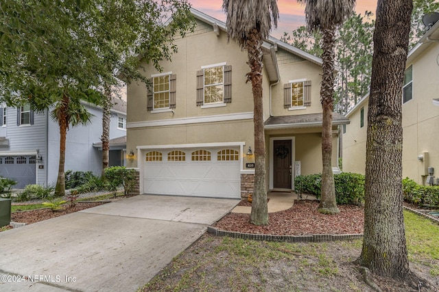 635 Briar View Dr, Orange Park, FL 32065 - traditional-style house featuring stone siding, a garage, concrete driveway, and stucco siding