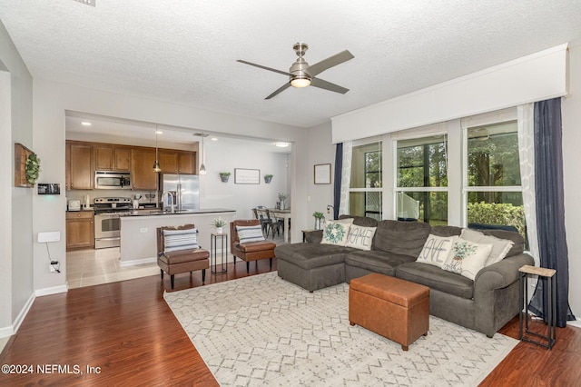 635 Briar View Dr, Orange Park, FL 32065 - living room featuring a textured ceiling, baseboards, ceiling fan, and wood finished floors