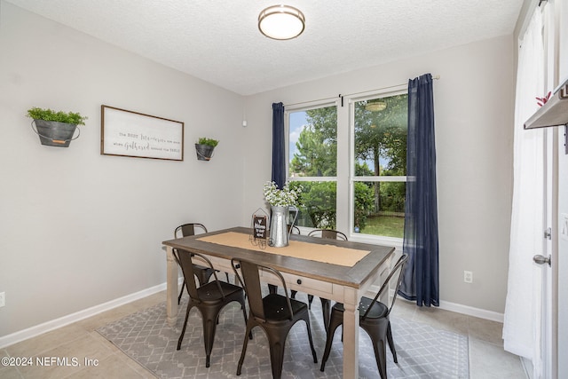 tiled dining space featuring a textured ceiling