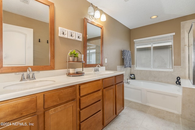 bathroom featuring independent shower and bath, vanity, tile patterned flooring, and a textured ceiling