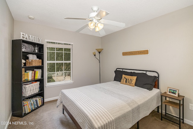 carpeted bedroom featuring a textured ceiling and ceiling fan