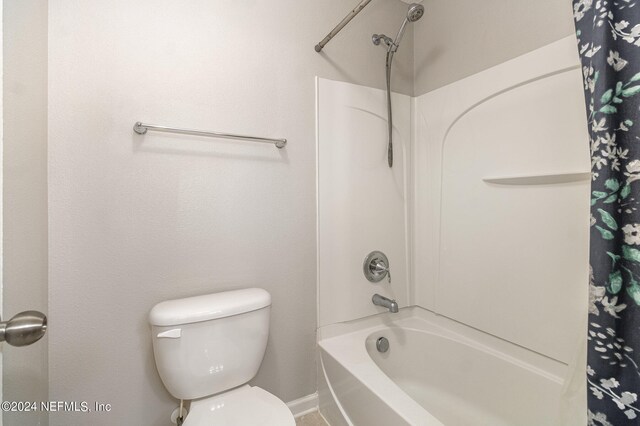 bathroom featuring toilet and shower / bath combo with shower curtain