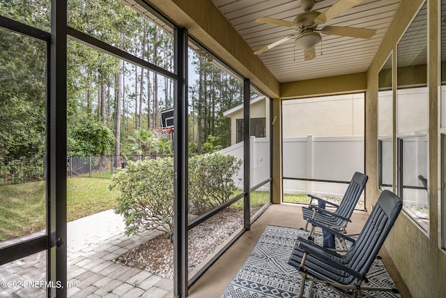 unfurnished sunroom featuring ceiling fan