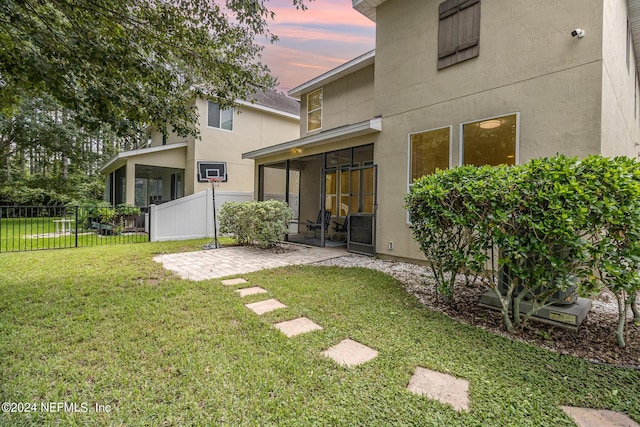 635 Briar View Dr, Orange Park, FL 32065 - back of house with a sunroom, stucco siding, fence, a yard, and a patio area