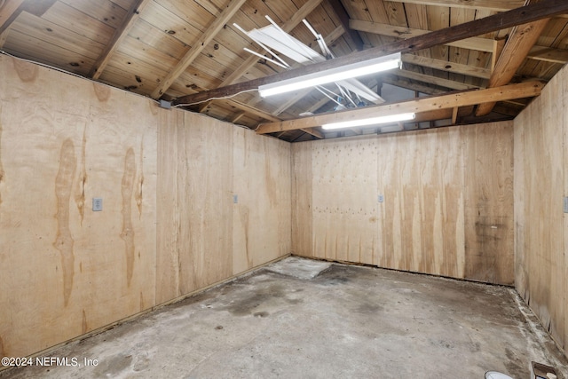 basement featuring wood walls