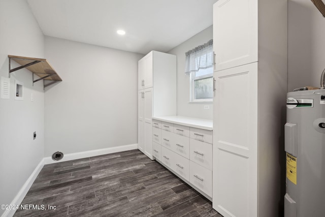 laundry area featuring electric water heater, cabinets, dark hardwood / wood-style flooring, and electric dryer hookup