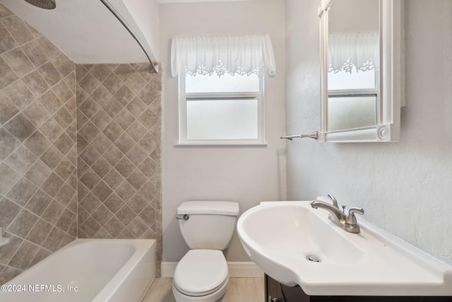 full bathroom with vanity, tiled shower / bath combo, and toilet