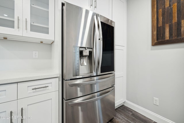 kitchen featuring stainless steel refrigerator with ice dispenser, dark hardwood / wood-style floors, white cabinetry, and light stone counters