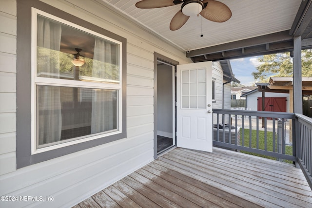 wooden terrace with cooling unit, a storage shed, and ceiling fan