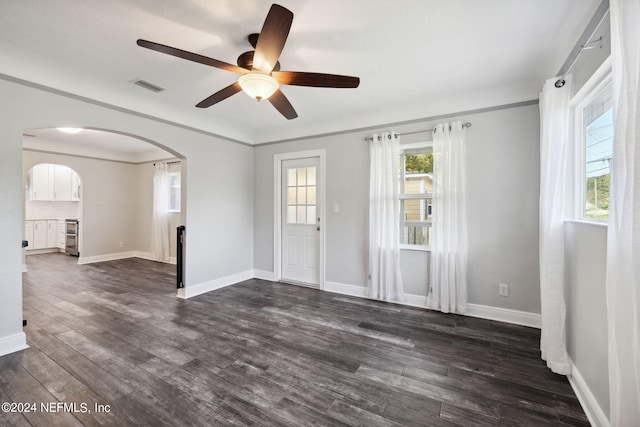 spare room featuring ornamental molding, ceiling fan, and dark wood-type flooring