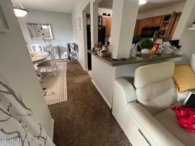 kitchen with kitchen peninsula and dark carpet