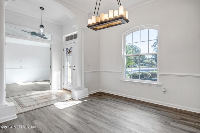 foyer with crown molding, wood-type flooring, and ornate columns