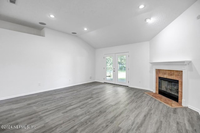 unfurnished living room with french doors, vaulted ceiling, a fireplace, and hardwood / wood-style flooring