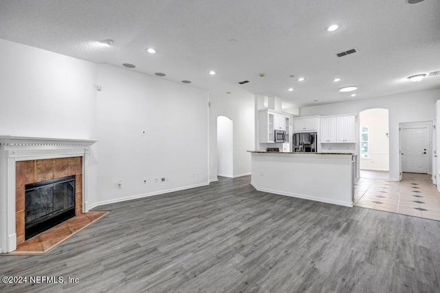 unfurnished living room featuring a fireplace and hardwood / wood-style flooring