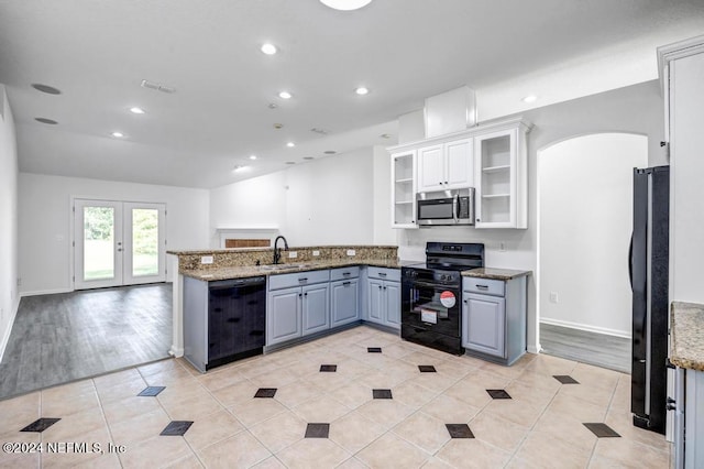 kitchen featuring sink, black appliances, white cabinets, and light hardwood / wood-style flooring