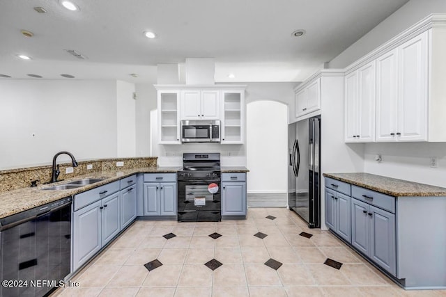 kitchen with sink, black appliances, white cabinetry, and light stone counters