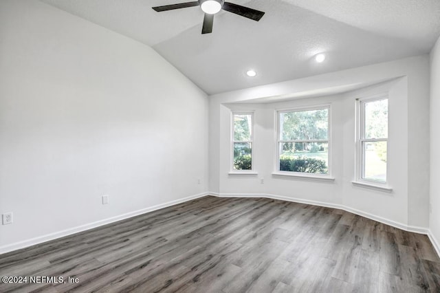 spare room with ceiling fan, a textured ceiling, lofted ceiling, and dark hardwood / wood-style floors