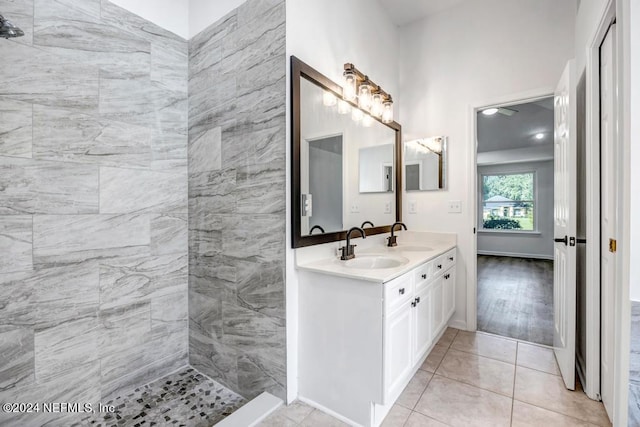 bathroom with vanity, tiled shower, and tile patterned flooring