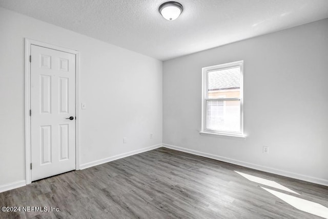 unfurnished room featuring a textured ceiling and hardwood / wood-style floors