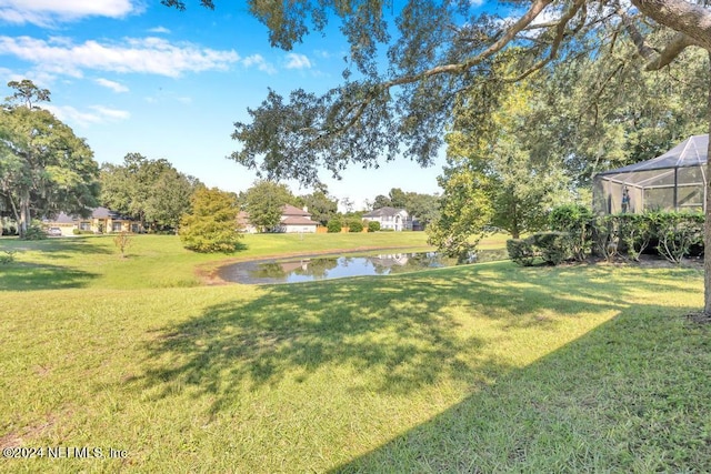 view of yard featuring a water view and glass enclosure