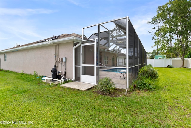 back of house with glass enclosure, a yard, a fenced in pool, and a patio area