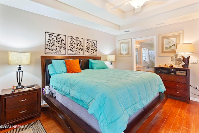 bedroom with connected bathroom, ceiling fan, and hardwood / wood-style flooring