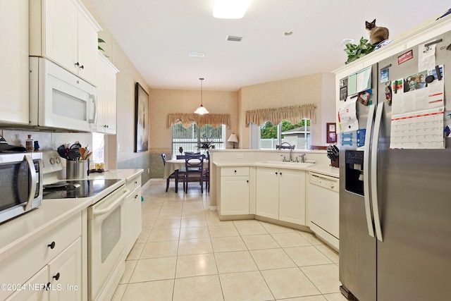 kitchen featuring appliances with stainless steel finishes, white cabinets, light tile patterned floors, pendant lighting, and sink