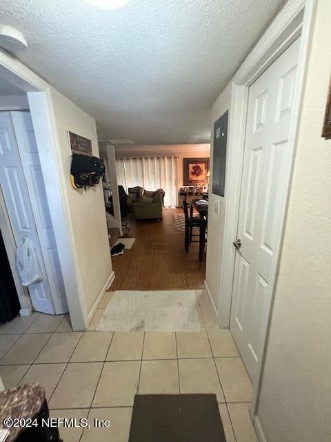 hallway featuring a textured ceiling and light hardwood / wood-style floors