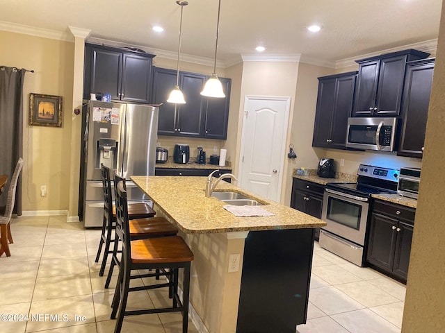 kitchen with a kitchen island with sink, a kitchen breakfast bar, sink, decorative light fixtures, and stainless steel appliances