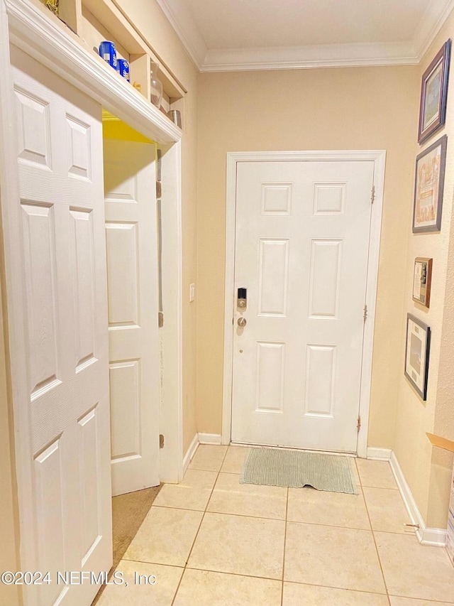 entryway featuring crown molding and light tile patterned flooring