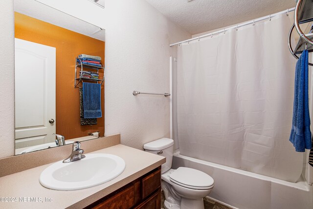 full bathroom with vanity, toilet, a textured ceiling, and shower / bath combo