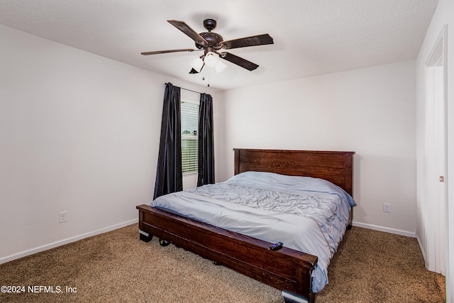 carpeted bedroom with ceiling fan and a textured ceiling