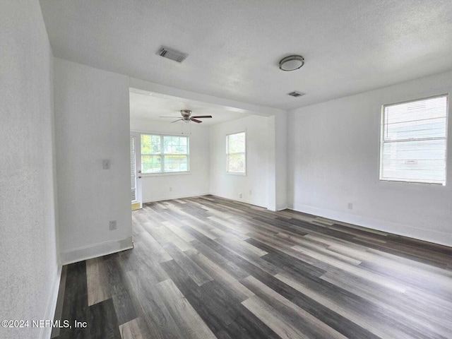 spare room with ceiling fan, a textured ceiling, and dark hardwood / wood-style flooring