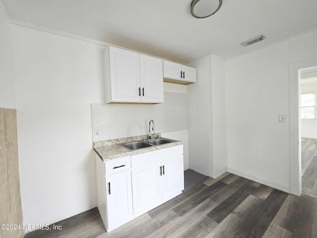 kitchen featuring crown molding, sink, white cabinets, and dark hardwood / wood-style floors