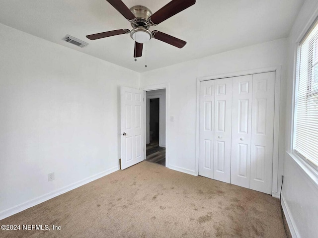 unfurnished bedroom with a closet, carpet, and ceiling fan