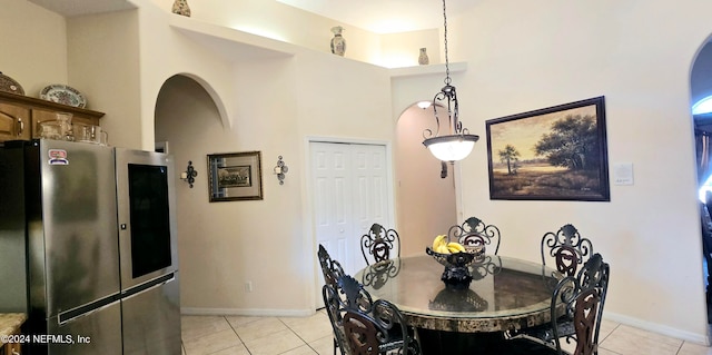 tiled dining room featuring a towering ceiling