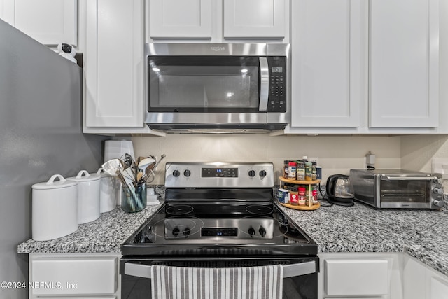 kitchen featuring light stone countertops, white cabinetry, and appliances with stainless steel finishes