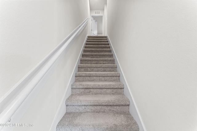 stairway featuring carpet