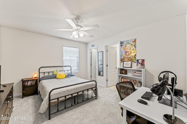 bedroom with ceiling fan, a textured ceiling, and light carpet