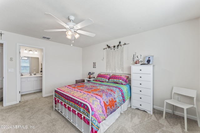 carpeted bedroom with ensuite bath and ceiling fan