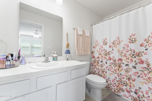 bathroom featuring curtained shower, vanity, ceiling fan, toilet, and tile patterned floors