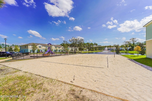 view of community featuring a playground, a water view, and volleyball court