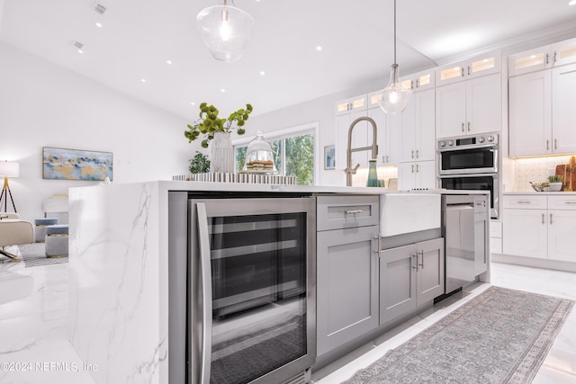 kitchen featuring pendant lighting, wine cooler, stainless steel double oven, and white cabinetry